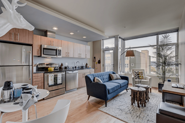 Seattle apartment for rent - a living room with a couch and a kitchen with a large window