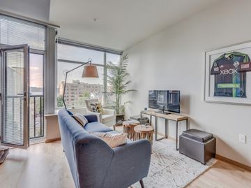 Seattle apartment for rent - A living room with a grey couch and a television.