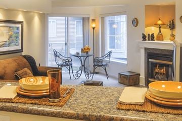 Anchorage apartment for rent - A living room with a fireplace and a dining table set for two.