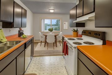 Anchorage apartment for rent - A kitchen with a white stove top oven and orange countertops.