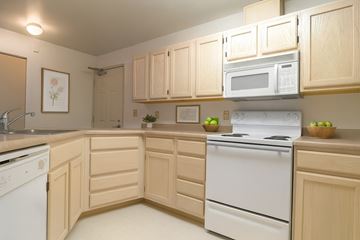Anchorage apartment for rent - A kitchen with wooden cabinets and white appliances.