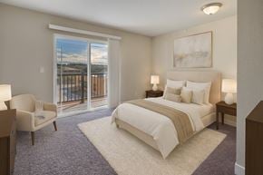 Anchorage apartment for rent - A bedroom with a large bed and a chair by a window.