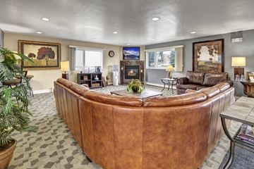 Anchorage apartment for rent - A living room with a brown leather couch and a fireplace.