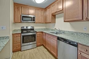 Anchorage apartment for rent - A kitchen with wooden cabinets and granite countertops.