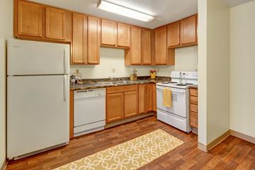 Anchorage apartment for rent - A kitchen with wooden cabinets and white appliances.
