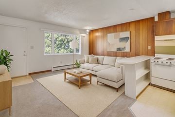 Anchorage apartment for rent - A living room with a couch, coffee table, and a painting on the wall.