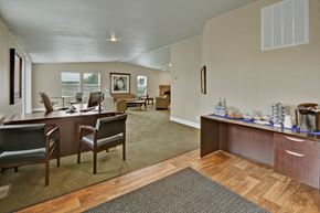 Anchorage apartment for rent - Welcoming, functional community space here at Four Seasons featuring a business center with desks and chairs, an open lounge area with comfortable seating, and a refreshment station with coffee and snacks. Neutral carpeting, wood-style flooring, and ample lighting create a convenient shared space for work and relaxation.