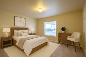 Anchorage apartment for rent - A cozy, well-lit bedroom here at Four Seasons featuring a modern wood bed frame with crisp white bedding, matching nightstands with soft table lamps, neutral wall art above the headboard, plush carpeting, a bright window for natural light, and a dresser with an accent chair creating a calm, inviting retreat.