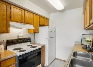 Anchorage apartment for rent - A kitchen with wooden cabinets and a white refrigerator.