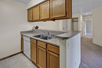 Anchorage apartment for rent - A kitchen with wooden cabinets and a white dishwasher.