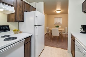 Anchorage apartment for rent - A kitchen with a white refrigerator and a dining table with chairs.