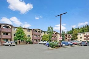 Anchorage apartment for rent - A parking lot in front of apartment buildings with cars parked.