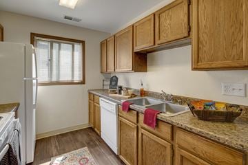 Anchorage apartment for rent - A kitchen with wooden cabinets and a white refrigerator.