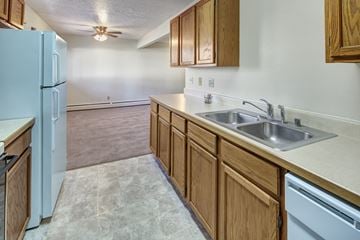 Anchorage apartment for rent - A kitchen with a white refrigerator and wooden cabinets.