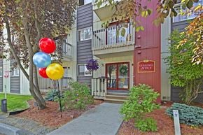 Anchorage apartment for rent - A leasing office is located in a building with a red door and a balcony.