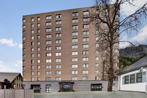 Juneau apartment for rent - Tall exterior building of Mendenhall-Tower with rows of large windows and a clearly marked main entrance at street level.