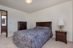 Anchorage apartment for rent - A bedroom with a bed, nightstand, and lamp.