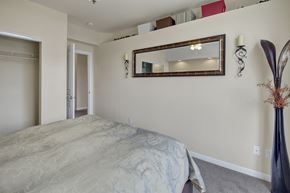 Anchorage apartment for rent - A bedroom with a large bed and a mirror above it.