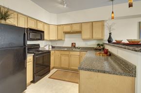 Anchorage apartment for rent - A kitchen with wooden cabinets and granite countertops.