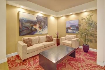 Anchorage apartment for rent - A living room with a couch, chair, coffee table, and two paintings on the wall.