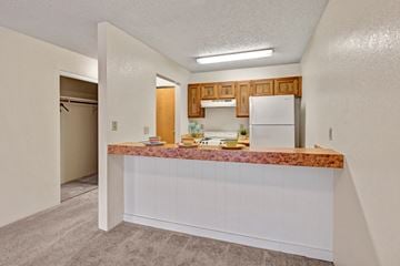 Anchorage apartment for rent - A kitchen with a white refrigerator and wooden cabinets.