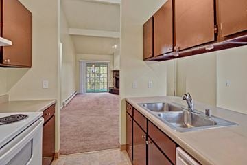 Anchorage apartment for rent - A kitchen with brown cabinets and a white stove top oven.