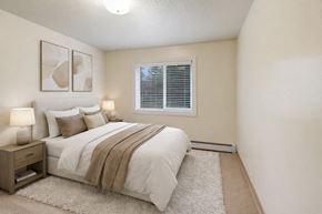 Anchorage apartment for rent - A bedroom with a bed, nightstand, and two framed pictures on the wall.