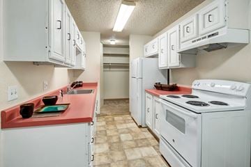 Anchorage apartment for rent - A kitchen with white cabinets and a red counter.