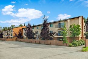Anchorage apartment for rent - A large building with a parking lot in front of it.