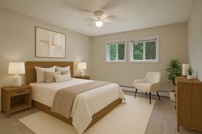 Anchorage apartment for rent - A bedroom with a large bed, a chair, and a plant.