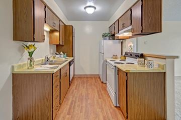 Anchorage apartment for rent - A kitchen with wooden cabinets and a white refrigerator.
