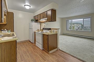 Anchorage apartment for rent - A kitchen with wooden cabinets and a white refrigerator.