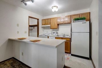 Anchorage apartment for rent - A kitchen with white appliances and wooden cabinets.