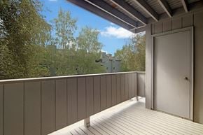 Anchorage apartment for rent - A balcony with a door and a view of a building in the distance.