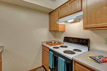 Anchorage apartment for rent - A kitchen with a stove top oven and wooden cabinets.