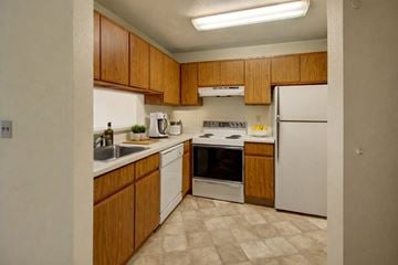 Anchorage apartment for rent - A kitchen with wooden cabinets and white appliances.