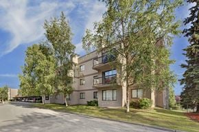 Anchorage apartment for rent - A large apartment building with a parking lot in front.