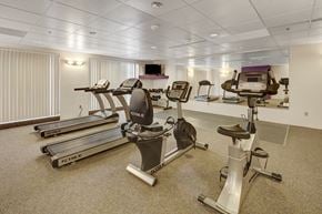 Anchorage apartment for rent - A gym with treadmills, elliptical machines, and stationary bikes.