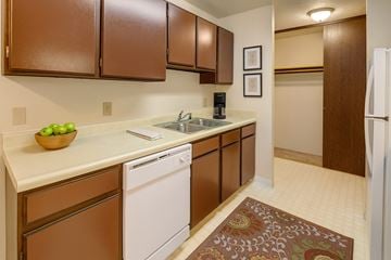 Anchorage apartment for rent - A kitchen with brown cabinets and a white dishwasher.