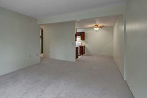 Anchorage apartment for rent - A spacious room with a ceiling fan and a doorway leading to another room.
