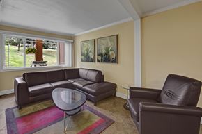 Anchorage apartment for rent - A living room with a brown leather couch, chair, and coffee table.