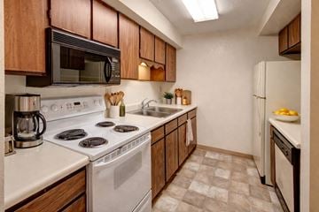 Anchorage apartment for rent - A kitchen with a white stove top oven and white countertops.