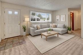 Anchorage apartment for rent - A living room with a grey couch, a coffee table, and a white door.