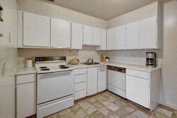 Anchorage apartment for rent - A kitchen with white appliances and cabinets.