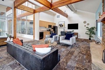 Anchorage apartment for rent - A modern living room with a black sofa and a wooden beam ceiling.