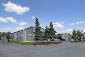 Anchorage apartment for rent - A large building with a parking lot in front of it.