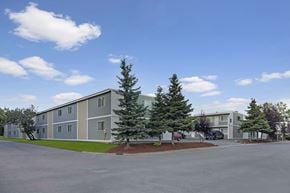 Anchorage apartment for rent - A large building with a parking lot in front of it.