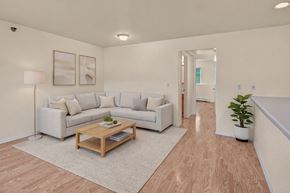 Eagle River apartment for rent - A living room with a white couch, a wooden coffee table, and a potted plant.
