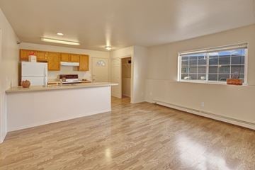 Eagle River apartment for rent - A kitchen with wooden cabinets and a white refrigerator.