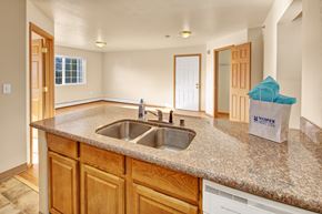Eagle River apartment for rent - A kitchen with a granite countertop and a white dishwasher.